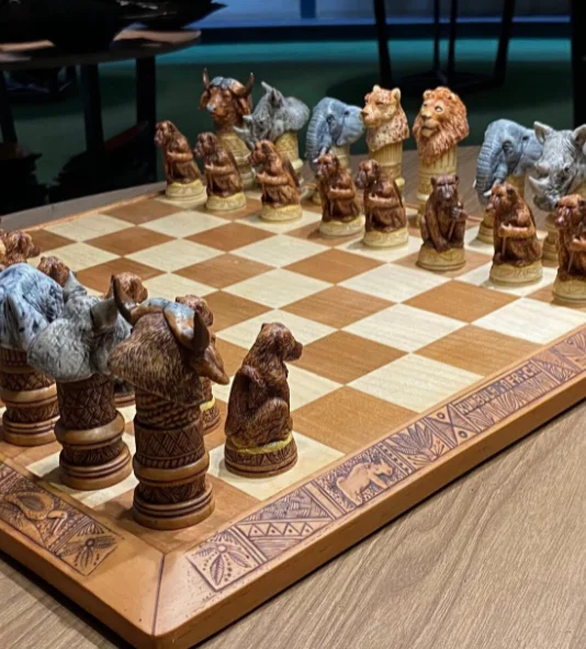Animal themed chess set on a wooden table